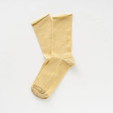 Pair of yellow socks on a light gray background