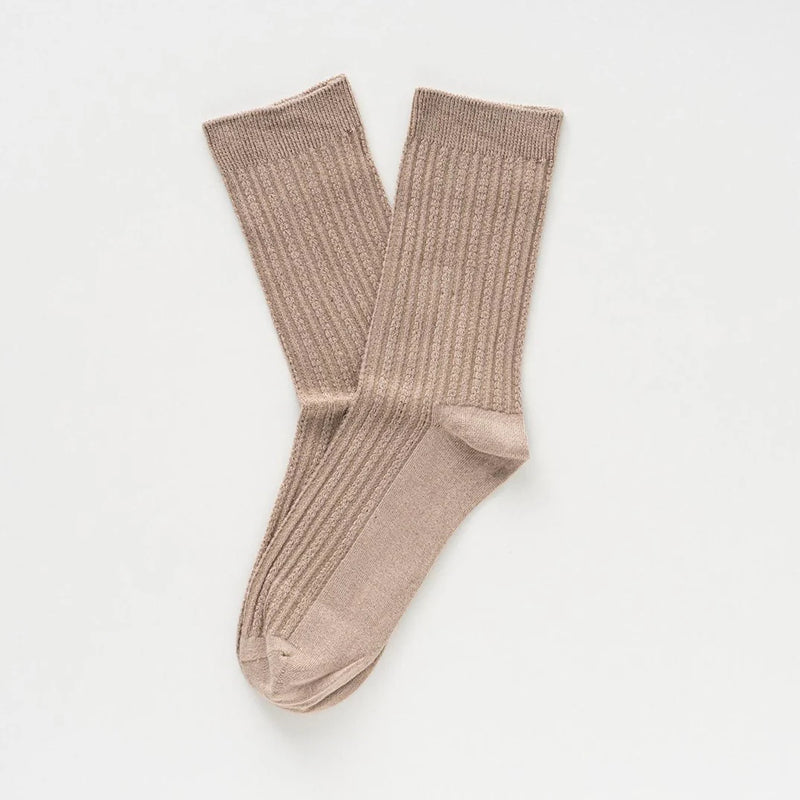 Pair of beige socks on a light gray background
