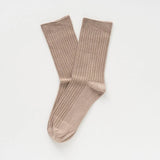 Pair of beige socks on a light gray background